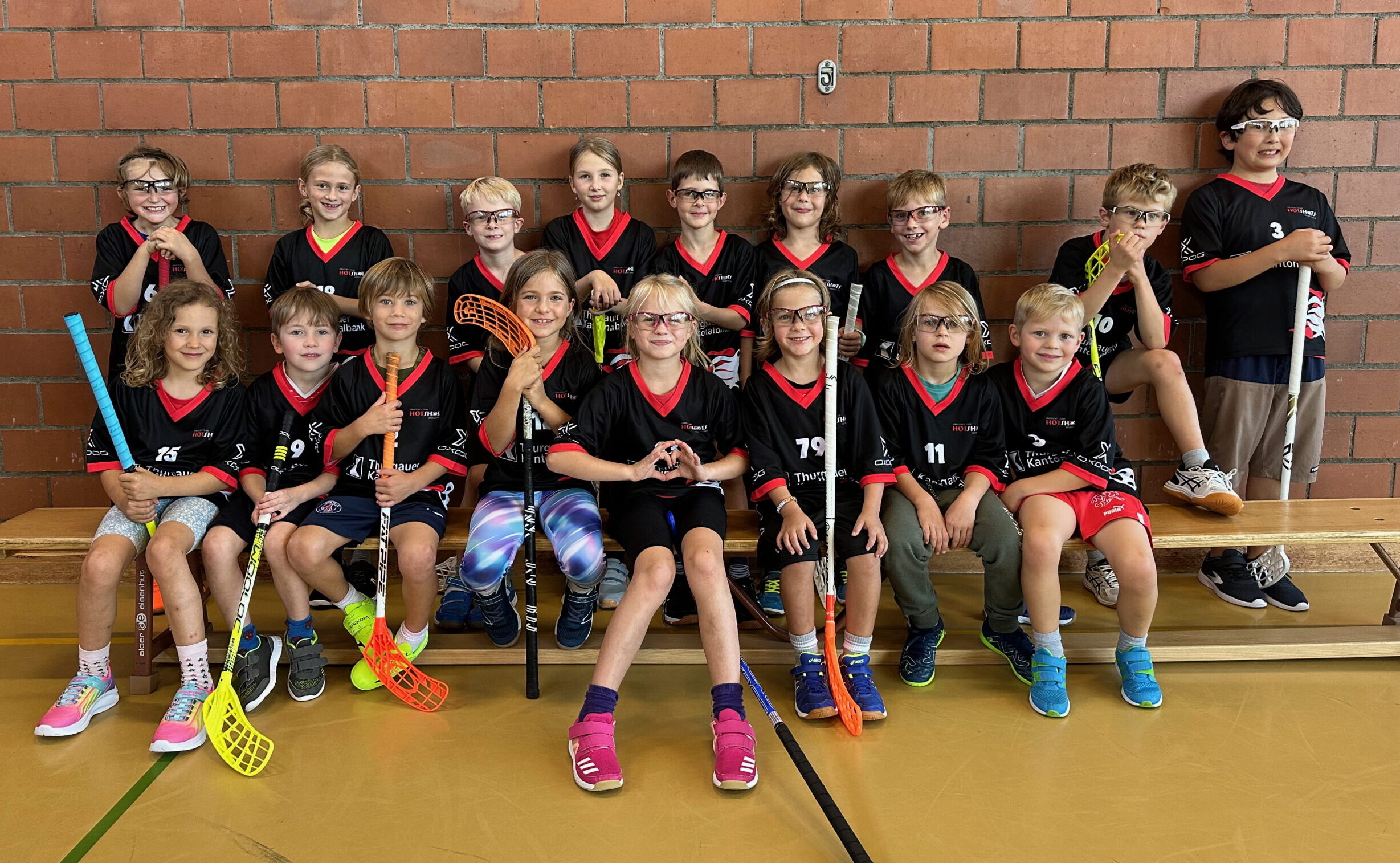 HotShots-Kids mit Stöcken und Schutzbrillen beim Teamfoto