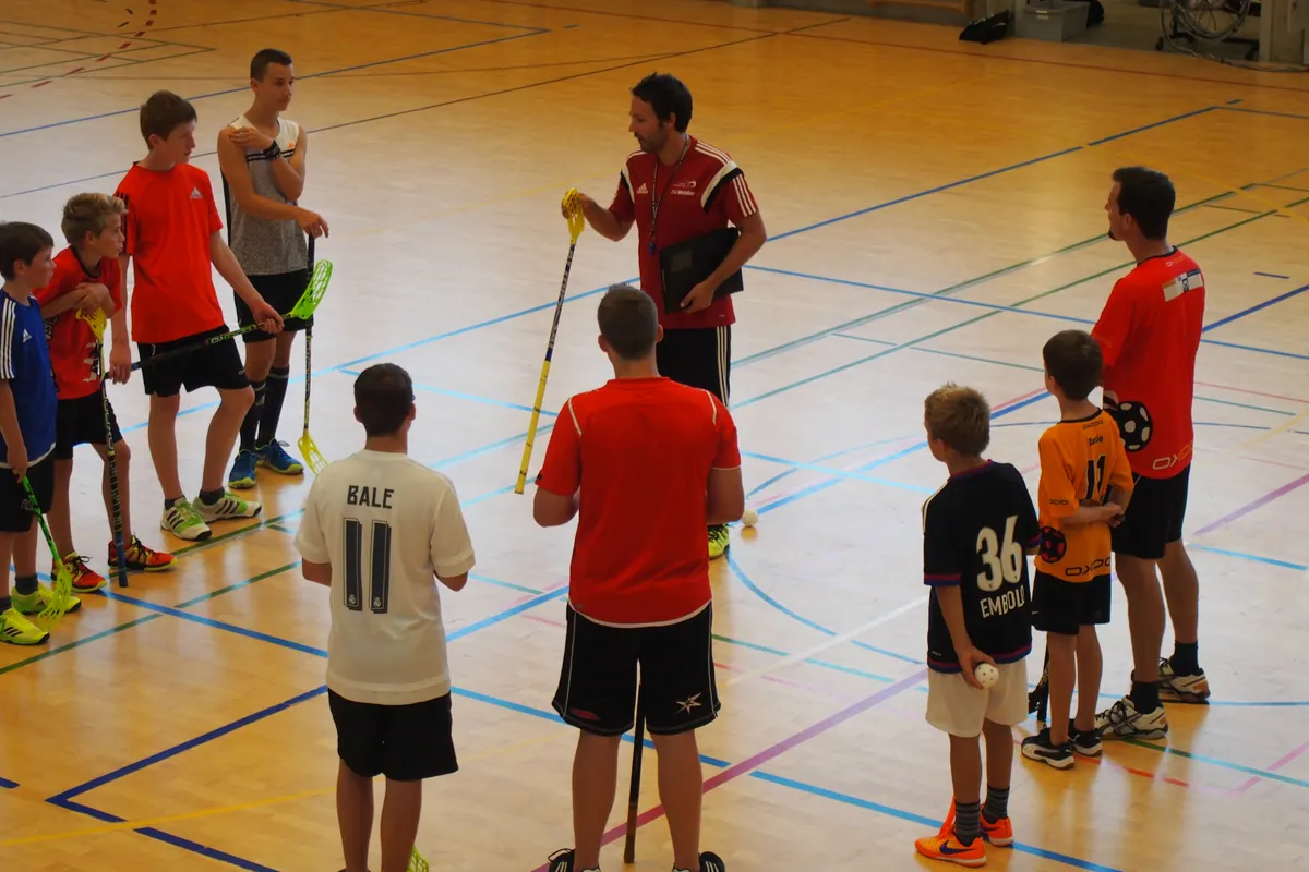 HotShots-Trainer erklärt Nachwuchsspielern eine Übung in der Unihockeyhalle