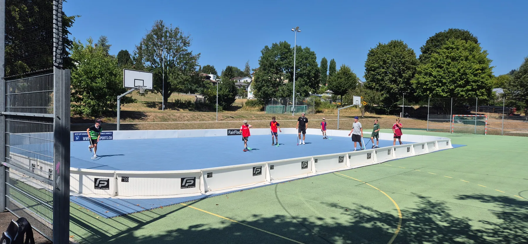 Kinder und Jugendliche spielen Street Floorball auf dem mobilen Feld im Freien