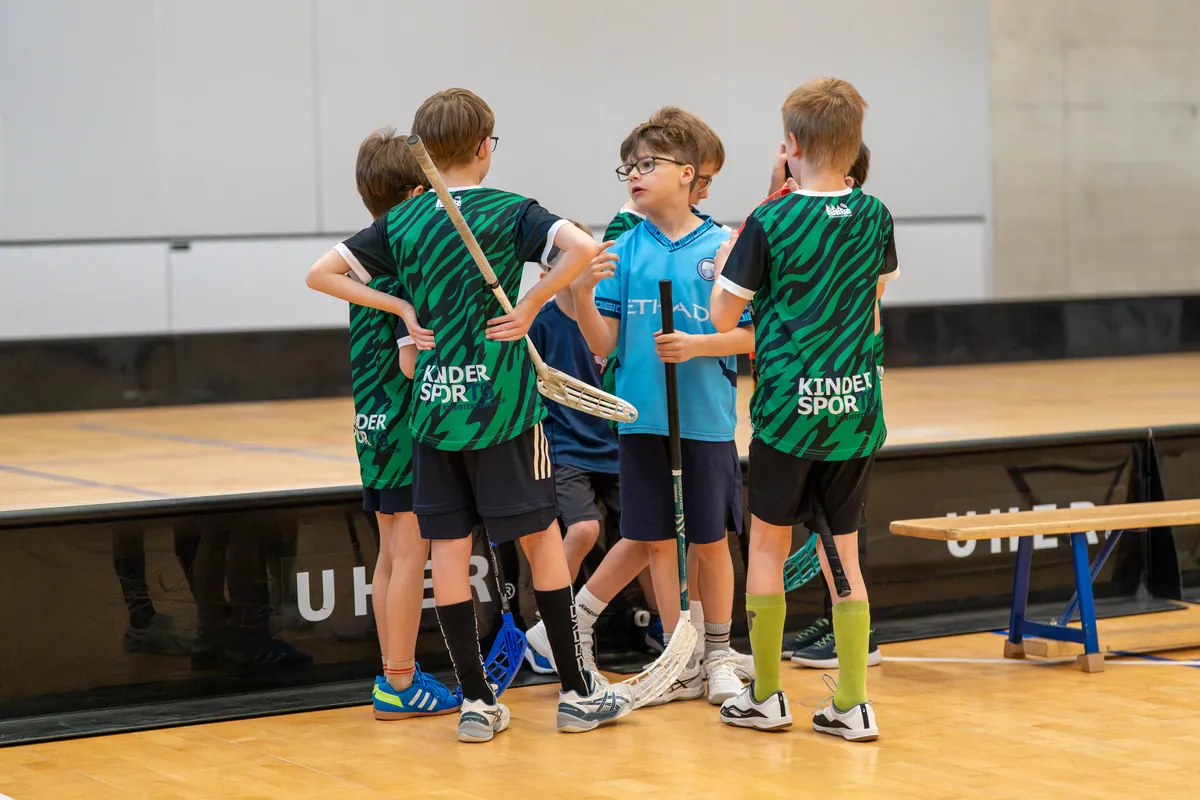 Kinder stehen als Team zusammen und besprechen das Spiel