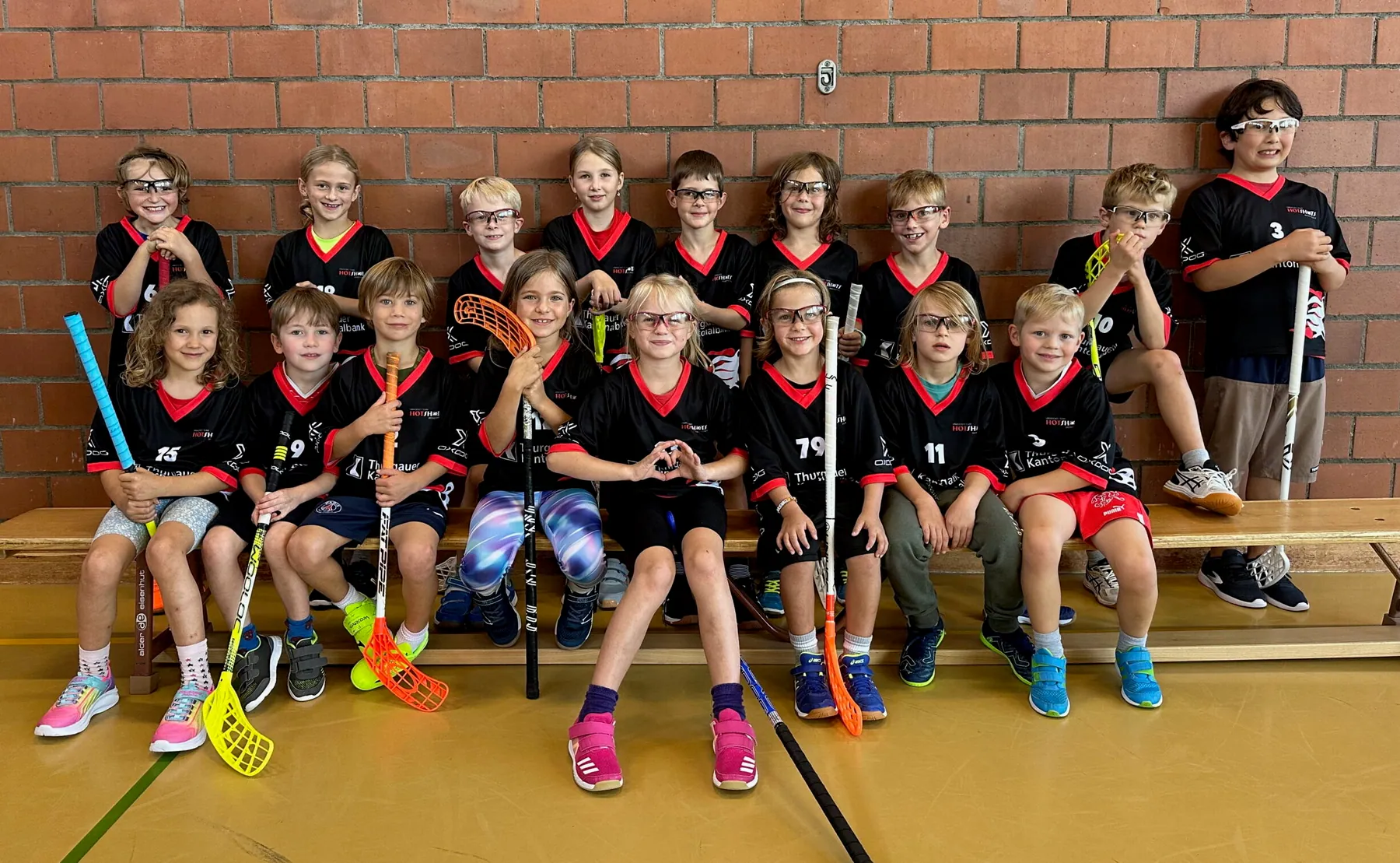 HotShots-Kids mit Stöcken und Schutzbrillen beim Teamfoto